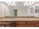 Bathroom featuring dual sinks with granite countertops and wood cabinets at 19429 Paddock View Dr, Tampa, FL 33647