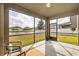 Covered patio with screened enclosure showcasing the backyard and pond view at 19429 Paddock View Dr, Tampa, FL 33647