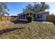 View of a large backyard with a screened-in porch and a wooden fence at 2609 Ridge Ln, Palm Harbor, FL 34684