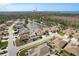 Lovely aerial view of residential neighborhood community with pond and verdant trees, with large body of water in the distance at 2619 Ravendale Ln, Holiday, FL 34691