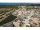 Beautiful aerial view of homes in a quiet neighborhood community with mature trees and a tranquil pond with ocean views beyond at 2619 Ravendale Ln, Holiday, FL 34691