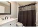 Cozy bathroom featuring a vanity with a white sink and a shower with a dark shower curtain at 2619 Ravendale Ln, Holiday, FL 34691