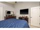 Bedroom featuring a flat-screen TV, dresser, a mirror, and a comfortable blue bed at 2619 Ravendale Ln, Holiday, FL 34691