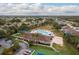 Gorgeous aerial view of community amenities including pool, clubhouse, tennis courts, and lush landscaping at 2619 Ravendale Ln, Holiday, FL 34691