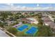 Gorgeous aerial view of community amenities including pool, clubhouse, tennis courts, and lush landscaping at 2619 Ravendale Ln, Holiday, FL 34691