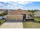 Charming single-Gathering home showcasing a three-car garage, mature landscaping, and a welcoming entryway at 2619 Ravendale Ln, Holiday, FL 34691