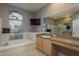 Light-filled bathroom features a soaking tub, large vanity, tile floors, and a glass-enclosed shower at 2619 Ravendale Ln, Holiday, FL 34691