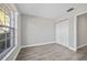 This bedroom features wood-look floors, a double closet, a window, and a light gray color scheme at 2914 Westmoreland Ct, New Port Richey, FL 34655