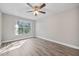 Bedroom features a ceiling fan, wood-look floors and natural light at 2914 Westmoreland Ct, New Port Richey, FL 34655