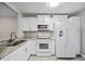 Well-lit kitchen featuring updated white appliances and a modern countertop at 2914 Westmoreland Ct, New Port Richey, FL 34655