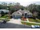 Aerial view of a single-story home with a three-car garage, manicured lawn, and mature trees at 3037 Crest Dr, Clearwater, FL 33759