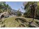 Lawn with mature trees featuring a large screened enclosure and pool at this residence at 3037 Crest Dr, Clearwater, FL 33759