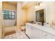 Bright bathroom featuring a shower-tub combo, crisp white cabinets, and neutral tile at 3037 Crest Dr, Clearwater, FL 33759