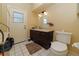 Bathroom featuring a vanity, toilet, tile floor, and door to the backyard at 3037 Crest Dr, Clearwater, FL 33759