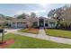 Charming single-story home featuring a three-car garage, lush landscaping, and a well-manicured lawn at 3037 Crest Dr, Clearwater, FL 33759