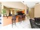 Kitchen bar with stools overlooking kitchen area with stainless appliances and wooden cabinets at 3037 Crest Dr, Clearwater, FL 33759