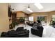 Living room featuring tile floors, skylights, a stone fireplace, and comfortable black leather sofas at 3037 Crest Dr, Clearwater, FL 33759