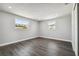 This bedroom features new dark laminate floors, light grey walls and trim, recessed lighting, and two windows providing natural light at 3246 Thorny Ridge Dr, Holiday, FL 34691