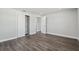 This bedroom features new dark laminate floors, light grey walls and trim, and a closet with sliding doors at 3246 Thorny Ridge Dr, Holiday, FL 34691