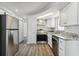 Well lit kitchen featuring white cabinets, stainless steel appliances, and gray backsplash at 3246 Thorny Ridge Dr, Holiday, FL 34691