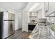 Well lit kitchen featuring white cabinets, stainless steel appliances, and gray backsplash at 3246 Thorny Ridge Dr, Holiday, FL 34691