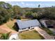 Aerial view of a single-story home with a gray roof surrounded by lush landscaping in a quiet neighborhood at 3373 Brodie Way, Palm Harbor, FL 34684