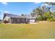 Spacious backyard with a screened porch and view of the surrounding greenery at 3373 Brodie Way, Palm Harbor, FL 34684