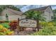 Elegant 'Highland Lakes Golf Club' sign amidst colorful flowers and lush landscaping, creating a welcoming entrance at 3373 Brodie Way, Palm Harbor, FL 34684