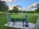 Picturesque golf course view featuring a bench, pond, and lush green fairways under a beautiful sky at 3373 Brodie Way, Palm Harbor, FL 34684