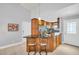 Bright kitchen featuring an island with bar seating, granite countertops, and custom wood cabinetry at 3373 Brodie Way, Palm Harbor, FL 34684