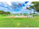 Flags fly behind a serene community area with benches surrounding a peaceful pond amid landscaped grounds at 36947 Beth Ave, Zephyrhills, FL 33542