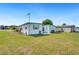 Exterior view of a well-maintained single-story home with green lawn and a shed at 36947 Beth Ave, Zephyrhills, FL 33542