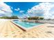 Community pool features lounge chairs and an awning for shade on a sunny day at 36947 Beth Ave, Zephyrhills, FL 33542