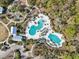 Aerial view showcasing a resort-style community pool with ample seating, a splash pad, and playground at 4594 Tour Trce, Land O Lakes, FL 34638