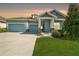 Beautiful exterior of home showing the 3 car garage, manicured lawn, and stone columns at 4594 Tour Trce, Land O Lakes, FL 34638