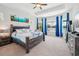 Bright main bedroom features a tray ceiling, large windows with blue drapes, and luxury vinyl plank flooring at 4594 Tour Trce, Land O Lakes, FL 34638