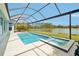 Sparkling pool and spa with a screened enclosure, overlooking a serene lake at 4594 Tour Trce, Land O Lakes, FL 34638