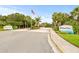 Community entrance with monument signage featuring mature landscaping, trees and American flag at 4620 Hidden View Pl # 10, Sarasota, FL 34235