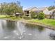 Scenic view featuring a serene pond with a fountain and charming residences with screened lanais at 4620 Hidden View Pl # 10, Sarasota, FL 34235