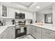 Kitchen featuring stainless steel appliances, marble backsplash, stone countertops, and gray and white cabinets at 4620 Hidden View Pl # 10, Sarasota, FL 34235