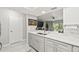 Kitchen featuring stainless steel sink, gray and white cabinets, stone countertops, and view to the living room at 4620 Hidden View Pl # 10, Sarasota, FL 34235