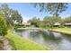 Picturesque pond with a fountain, surrounded by lush greenery and mature trees at 4620 Hidden View Pl # 10, Sarasota, FL 34235