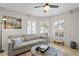 Bright living room with a beige sofa, round wooden coffee table, and travertine flooring at 4810 W San Miguel St, Tampa, FL 33629