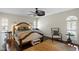 A primary bedroom featuring hardwood floors, a ceiling fan, stylish furniture, and a decorative area rug at 4810 W San Miguel St, Tampa, FL 33629