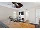 Relaxing main bedroom with hardwood floors, chair, bench, TV, ceiling fan, and access to the bathroom at 4810 W San Miguel St, Tampa, FL 33629