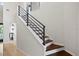 View of the staircase with wood treads and modern black metal railing at 4810 W San Miguel St, Tampa, FL 33629