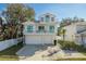 Two-story home features a double garage, turquoise doors, and charming balconies at 512 Oceanview Ave, Palm Harbor, FL 34683