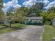 Charming single-story home with a spacious driveway and a large, shady tree in the front yard at 5504 60Th N Way, St Petersburg, FL 33709