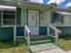 Close-up shot of the home's entrance, featuring steps up to the front door with a white handrail at 5504 60Th N Way, St Petersburg, FL 33709