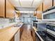 Functional kitchen with stainless steel sink, wooden cabinets, and a view into the living area at 5504 60Th N Way, St Petersburg, FL 33709